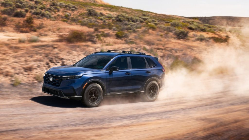 Blue Honda SUV driving on a dusty off-road trail