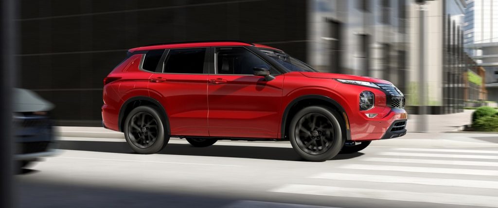 Red Nissan SUV in motion on a city street