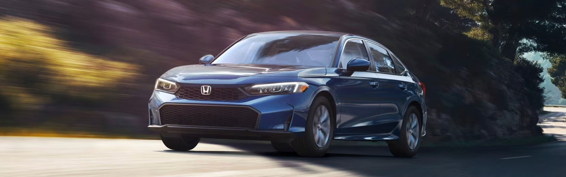 Blue Honda sedan driving on road.